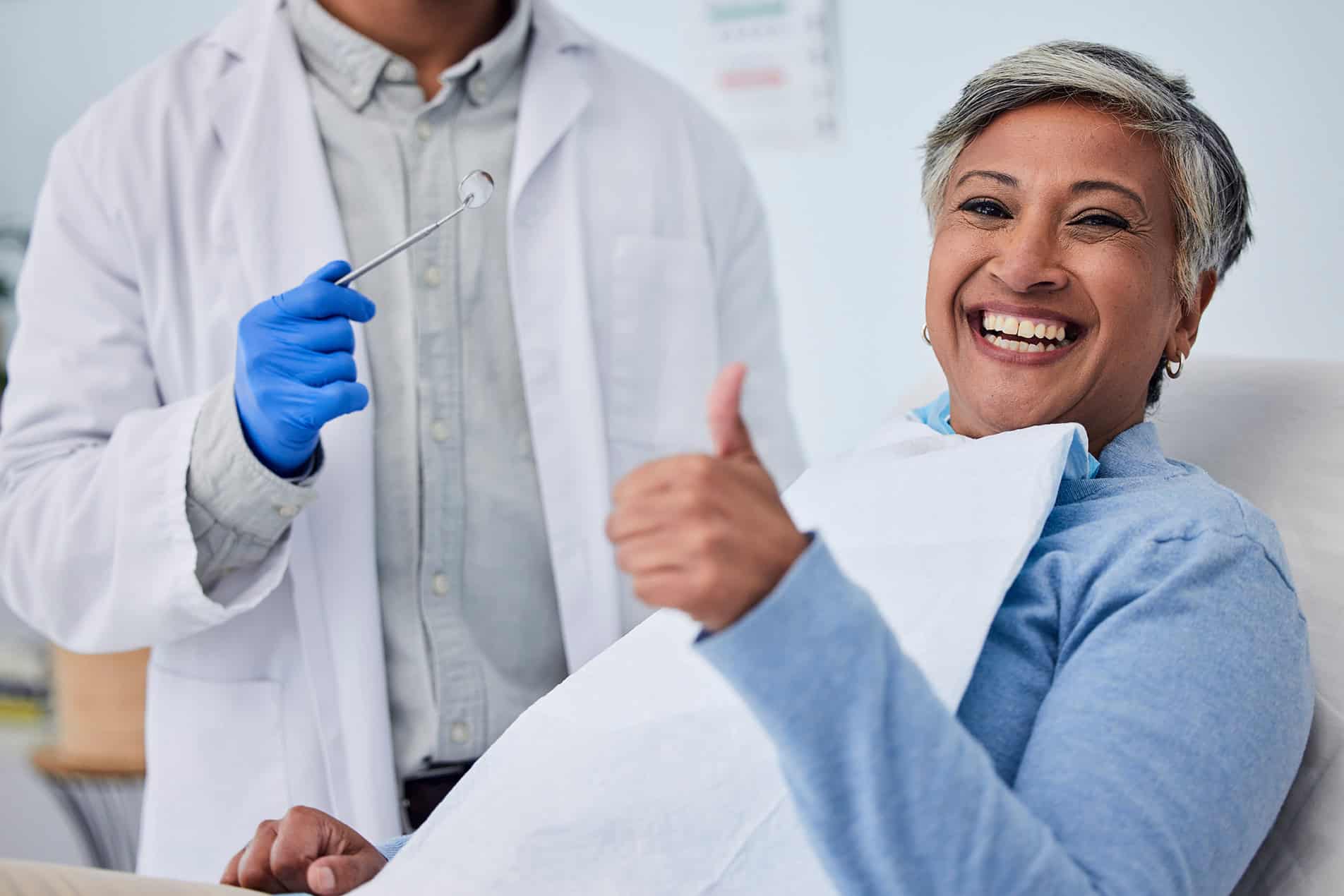 Happy woman, teeth and thumbs up for dentist in dental care, appointment or checkup at clinic